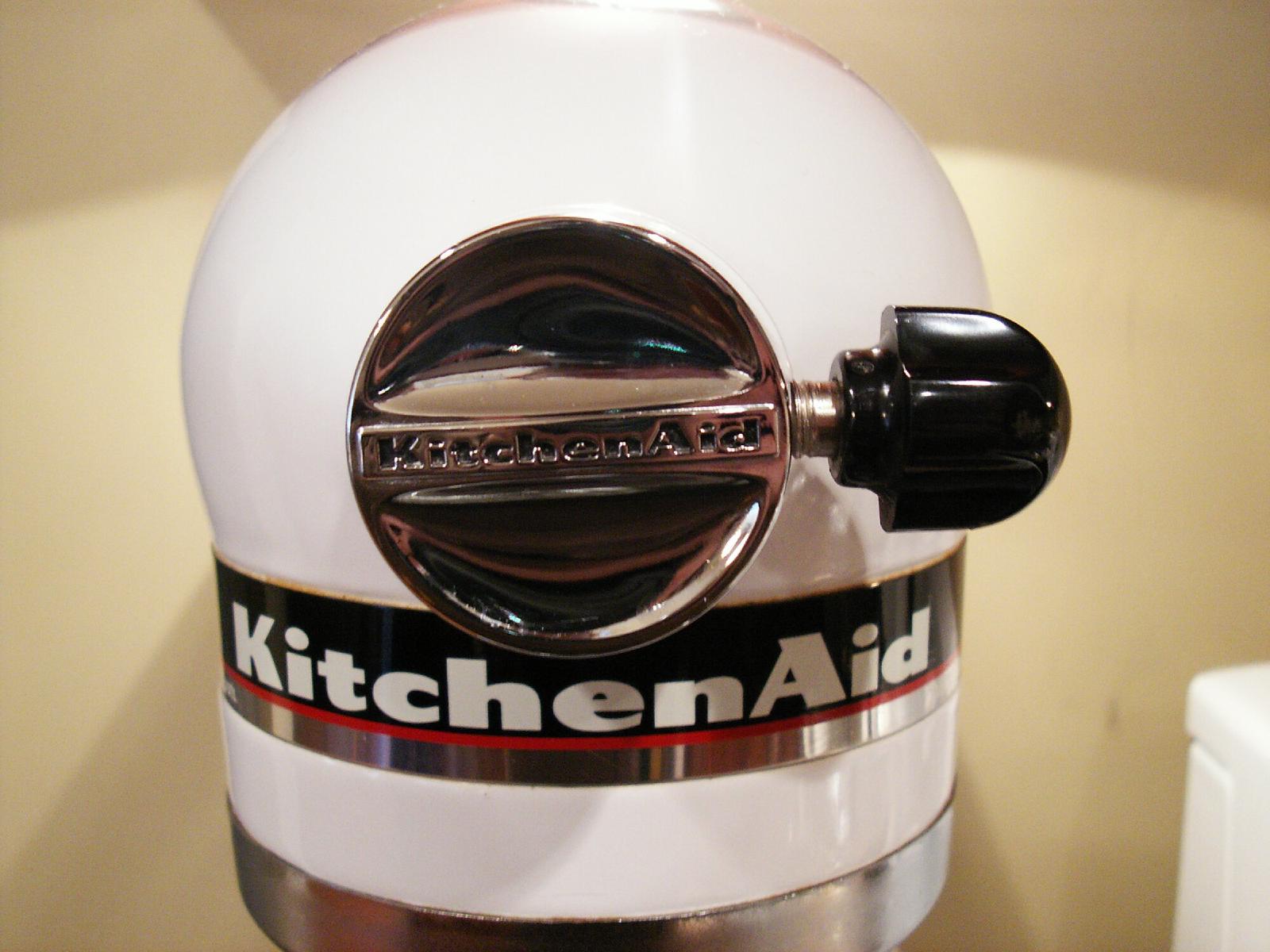 Head of a white KitchenAid stand mixer, close up on the chrome attachment hub