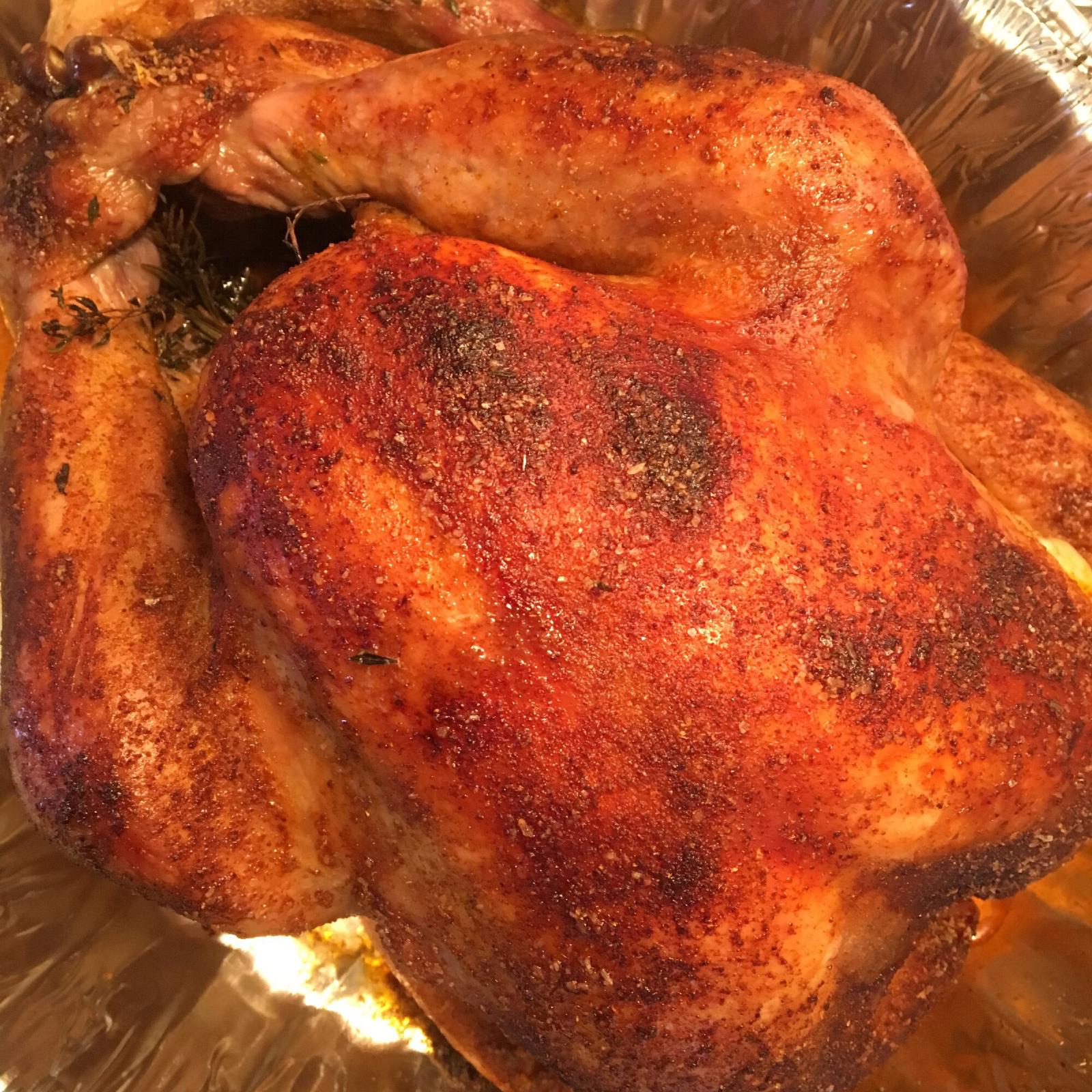 Whole roast chicken with a paprika rub and thyme, in a foil pan